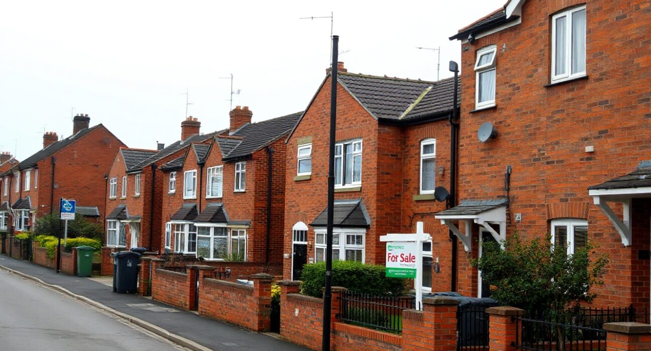 UK residential street with a For Sale sign, representing the housing market in July