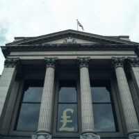 Bank of England building in London on a cloudy day, symbolizing UK monetary policy uncertainty.
