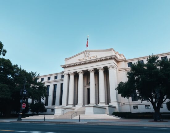 Federal Reserve building in Washington, D.C., with clear sky, symbolizing monetary policy decisions.