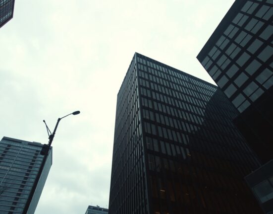 Modern office building exterior under overcast sky, representing US employment and economic conditions.