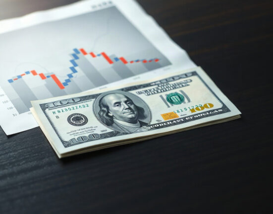 US dollar banknote with a declining yield chart in the background