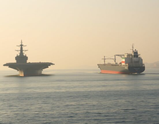 US Navy carrier and Iranian tanker in Strait of Hormuz illustrating US Iran military action tensions
