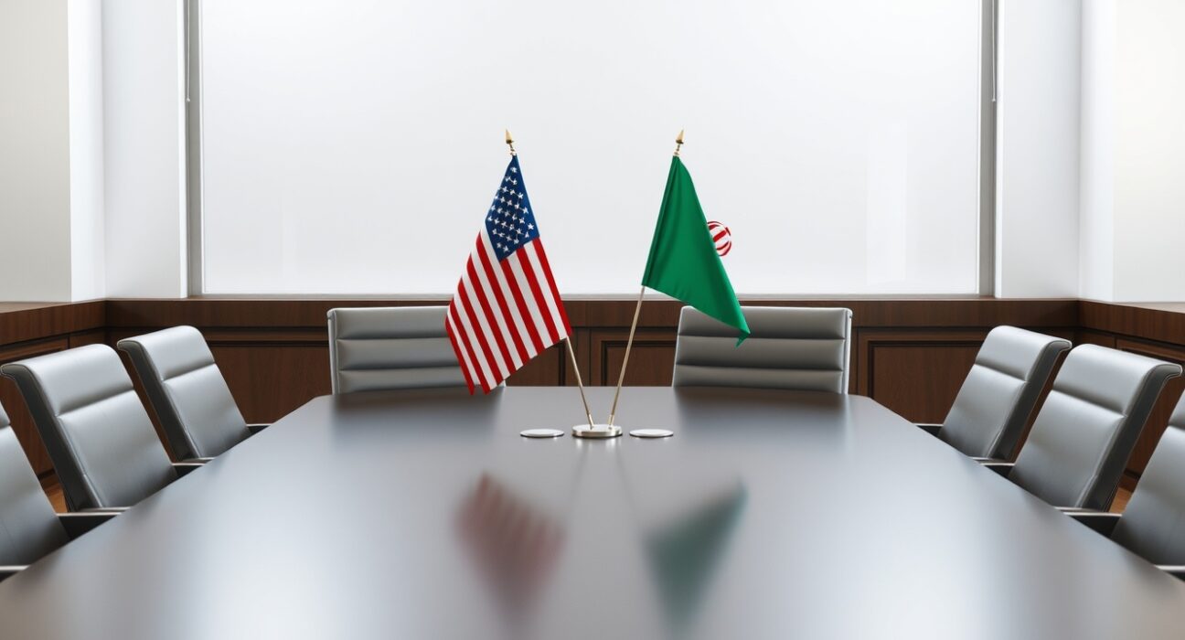 US and Iranian flags on a conference table symbolizing diplomatic negotiations