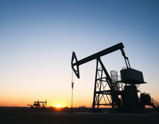 Oil drilling rig against a sunset sky in an open field, representing US drilling activity.