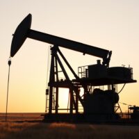 Oil drilling rig at sunset on open landscape representing US energy production activity