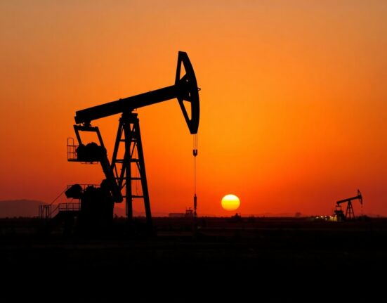 Oil drilling rig at dusk on a plain, symbolizing US drilling activity.