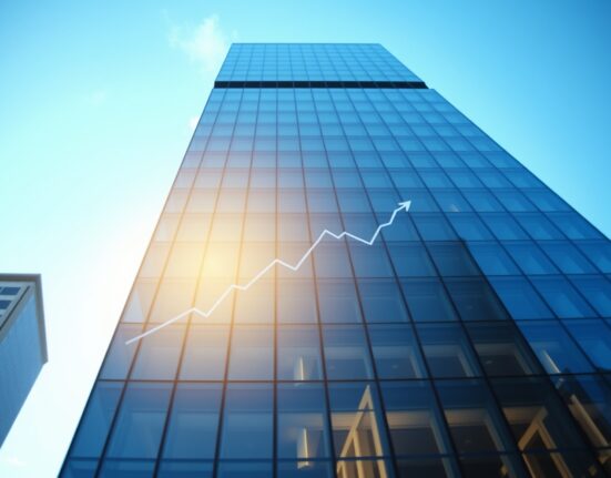 Modern office building in a US city reflecting a clear blue sky, symbolizing steady economic growth.