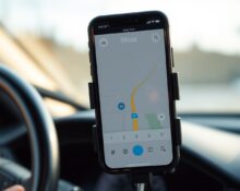 Smartphone displaying Waze navigation app with AI features on a car dashboard