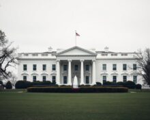 The White House on a cloudy day, representing government oversight of AI safety.