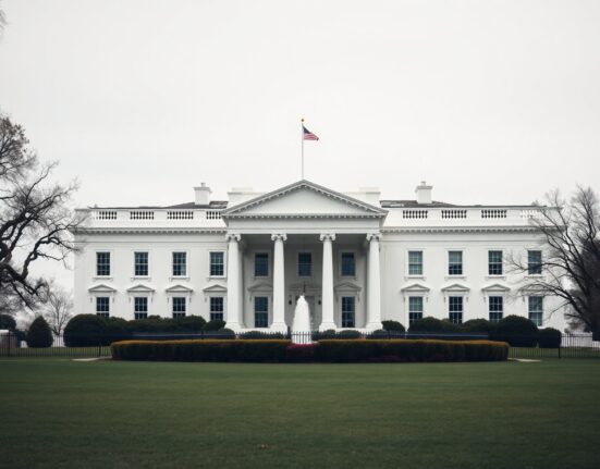 The White House on a cloudy day, representing government oversight of AI safety.