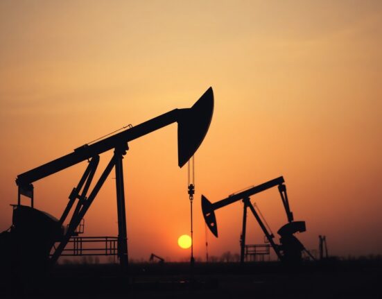 Crude oil pumpjack against muted sunset sky representing WTI price near March lows