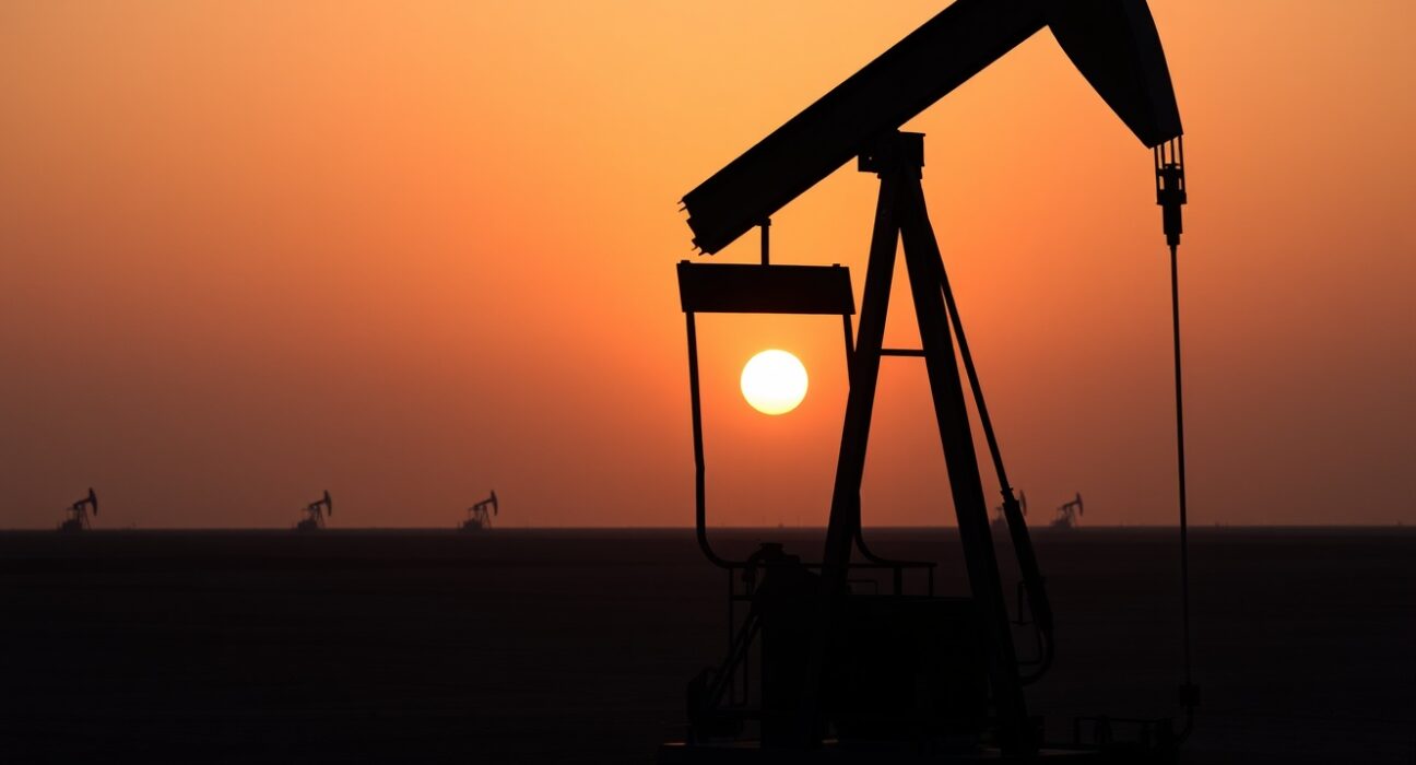 Oil pumpjack silhouetted against sunset sky representing WTI crude oil market retreat