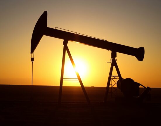 Oil pumpjack silhouette at sunset representing steady crude oil markets
