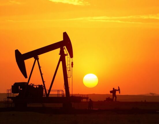 Oil pumpjack silhouette against smoky sunset sky, representing geopolitical risk to crude supply