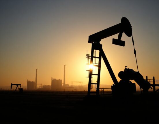 Crude oil pumpjack in an oil field at dawn, representing oil supply and market dynamics.