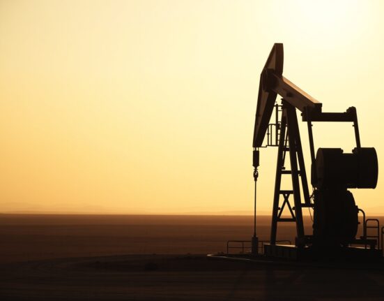 Oil pumpjack silhouetted against a hazy sky, representing WTI crude oil price movements amid geopolitical tensions.