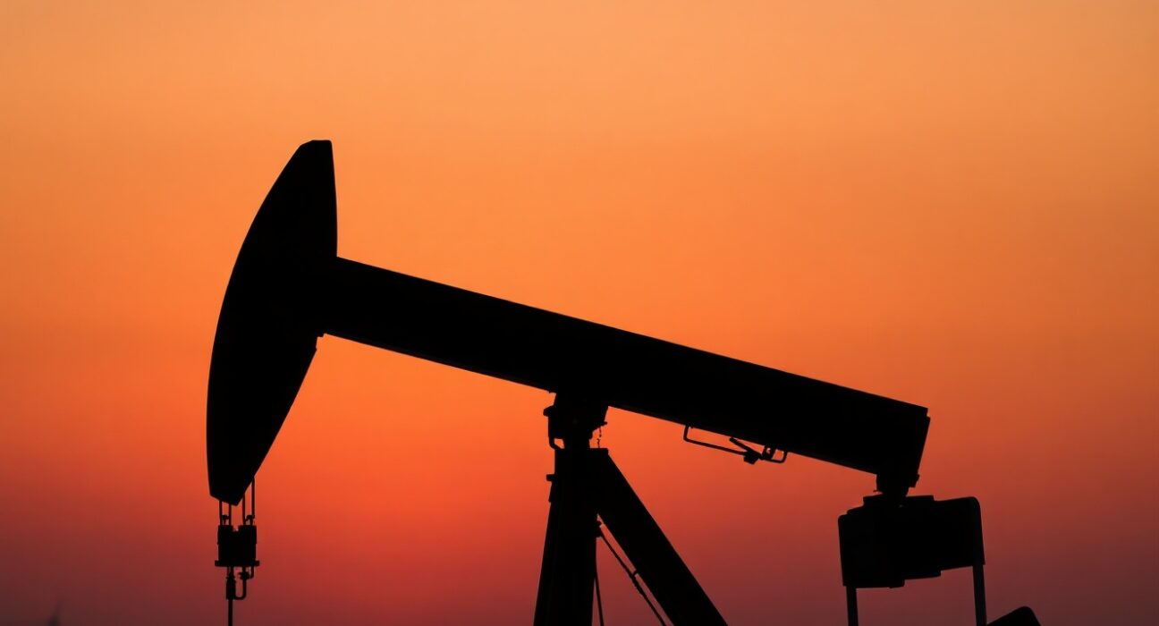 Oil pumpjack silhouetted at sunset representing WTI crude oil market
