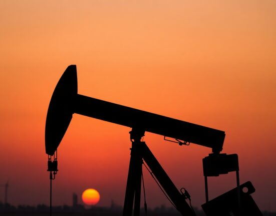 Oil pumpjack silhouetted at sunset representing WTI crude oil market
