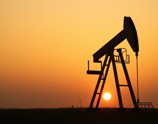 Oil pumpjack silhouette at sunset with diplomatic imagery in background representing Iran oil supply talks