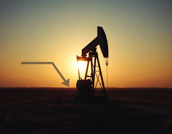 Oil pumpjack silhouette at sunset with faint downward arrow symbolizing falling WTI crude prices