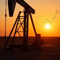 Oil pumpjack silhouette with chart line showing 20-day EMA resistance level at sunset