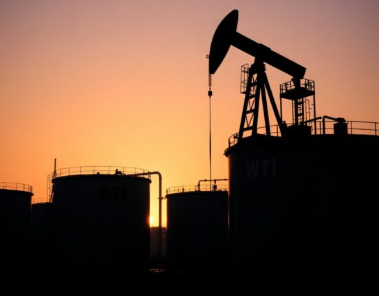 WTI crude oil storage tanks and pumpjack at an oil facility at sunset.