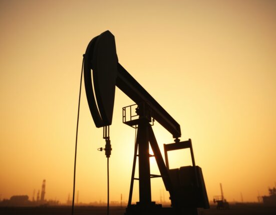 Crude oil pumpjack silhouetted against a hazy sunset sky, representing energy market uncertainty