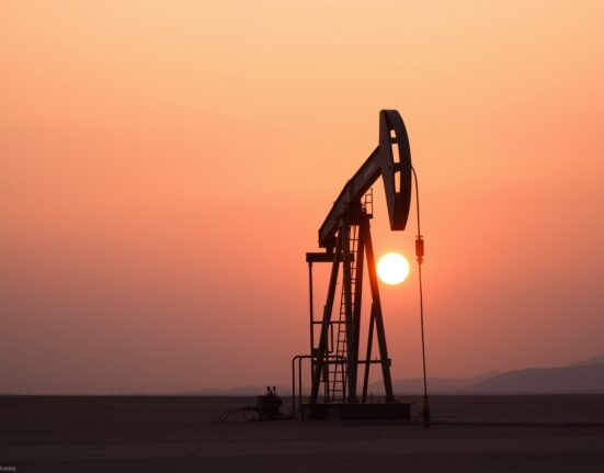 Oil pumpjack silhouette at sunset representing pause in WTI crude rally amid US-Iran de-escalation signals