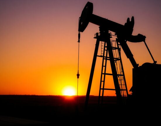 Oil pumpjack silhouette at sunset representing crude oil price volatility amid geopolitical tensions