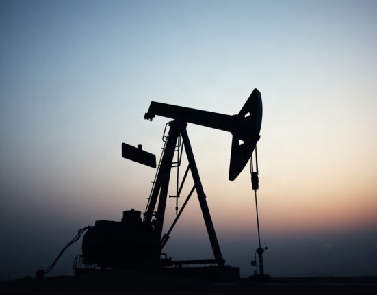 Crude oil pumpjack silhouette against overcast sky, representing WTI price movements.