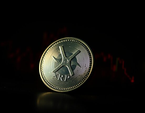 XRP cryptocurrency token with bearish market chart in the background